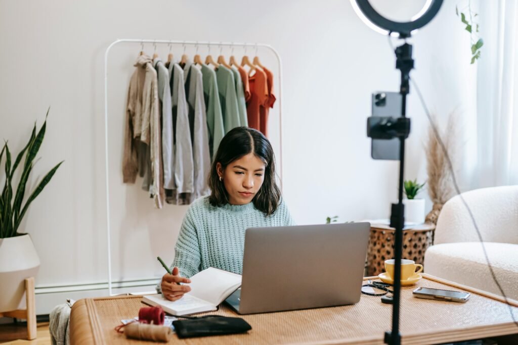 Woman writing on notebook and computer.