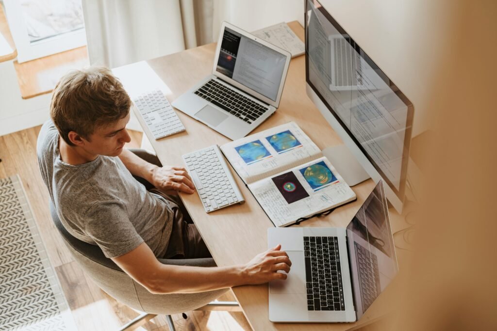 Man sitting in front of multiple computers.